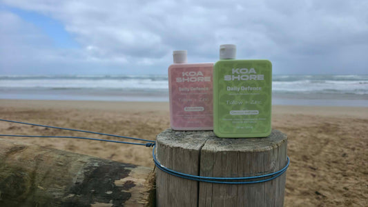 Koa Shore Daily Defence on a beach post — moisturiser for surfers