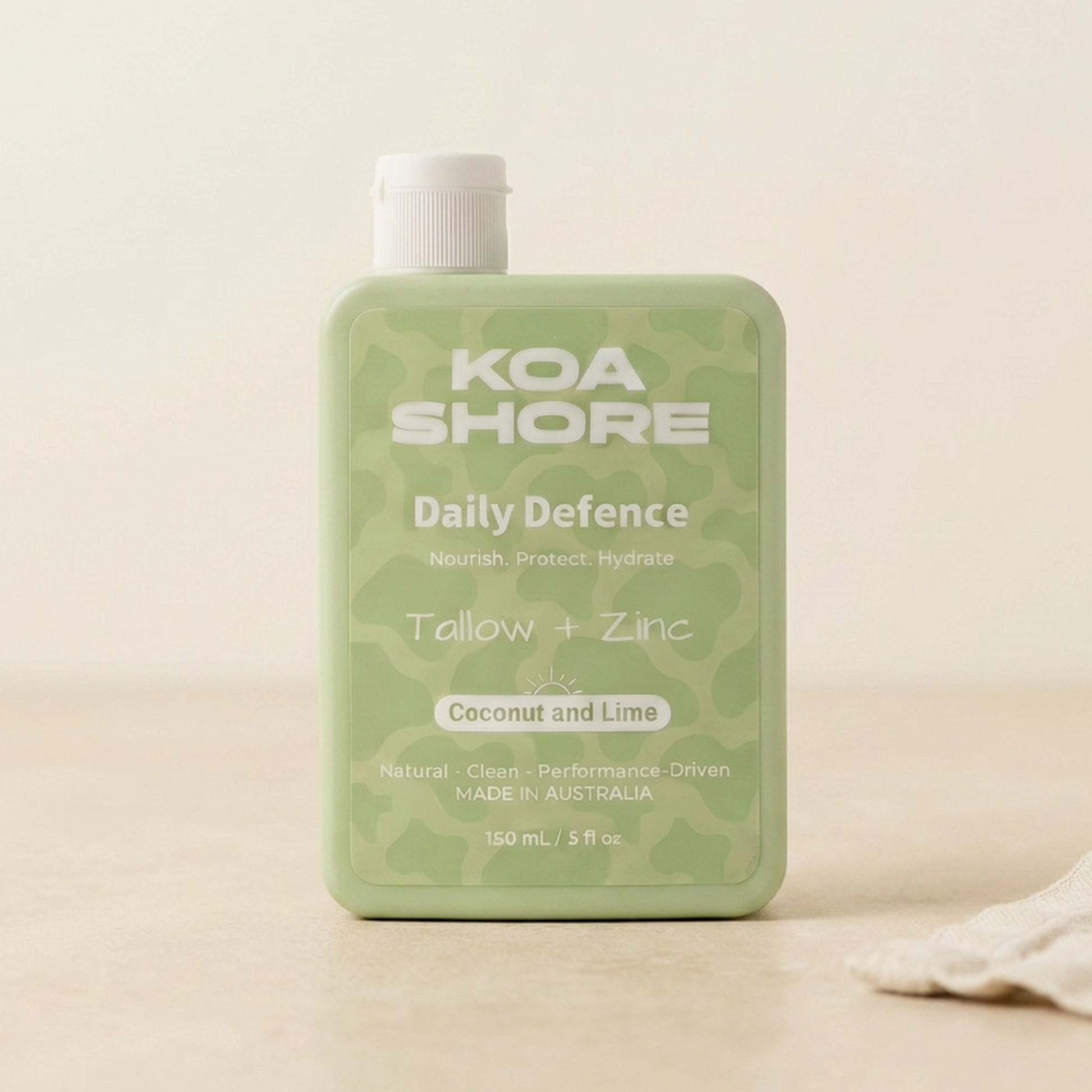 Koa Shore Daily Defence Coconut and Lime bottle on warm sand with linen