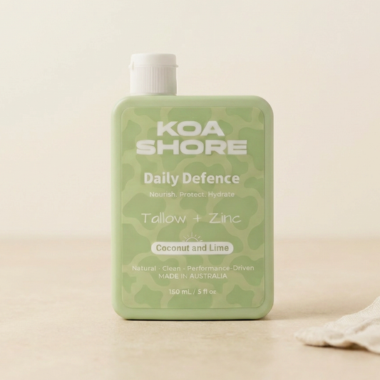Koa Shore Daily Defence Coconut and Lime bottle on warm sand with linen